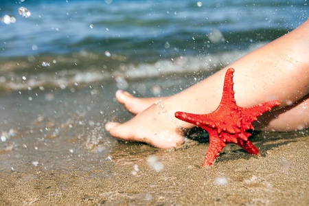 woman's barefoot on beach in waves, relaxing footの写真素材