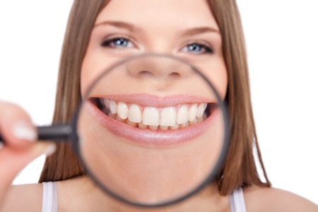young woman showing her healthy teeth, isolated over white backgroundの写真素材