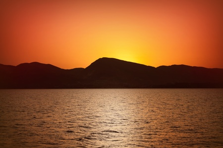 sunset landscape - sea, mountains, yellow skyの写真素材