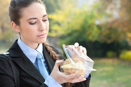 Portrait of a caucasian businesswoman eating donut princess, outdoorの写真素材