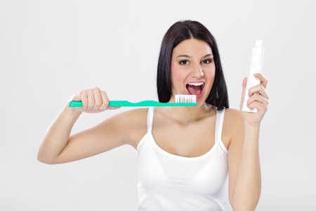 Beautiful girl holding toothpaste and brush, ready for brushingの写真素材