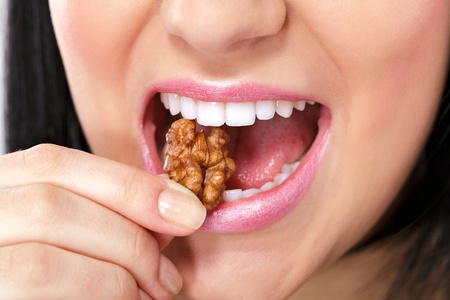 Close up of female mouth eating nut の写真素材