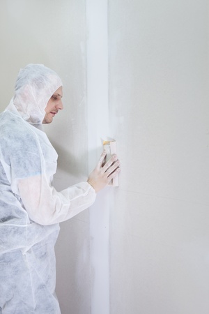 
young plasterer  in protective clothing polishing wallの写真素材