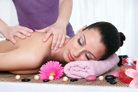 Young female getting a body massage at the day spaの写真素材