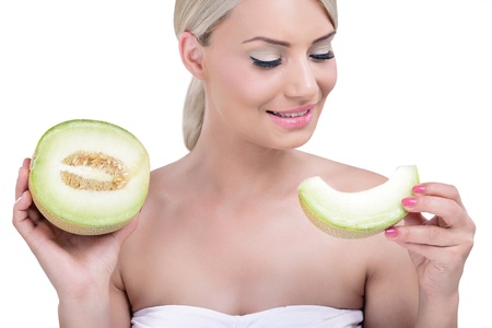 Portrait of healthy smiling woman holding a slice of cantaloupeの写真素材