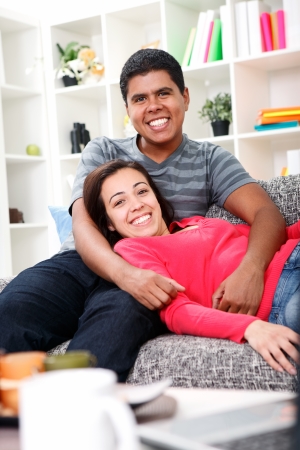 Happy young couple sitting on sofa at homeの写真素材