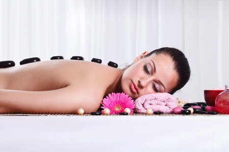 
Relaxed woman in spa center with hot stone on backの写真素材