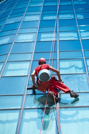 Washer wash the windows of modern skyscraper, high risk workの写真素材