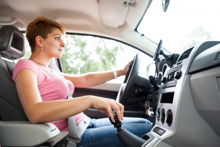 
woman driving car and  changing gear,  hand and gearshift in focus の写真素材