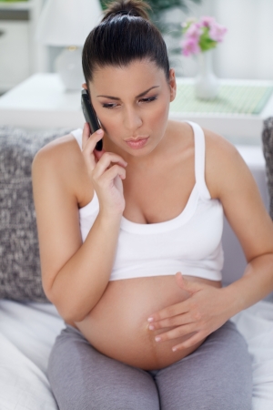 young pregnant woman talking on mobile phone,  an emergency call or call for helpの写真素材