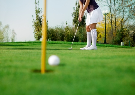 golfer and his ball just inches from the holeの写真素材