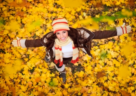 happy lovely and beautiful woman in forest in fall colors, celebrating coming autumnの写真素材