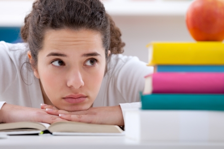 
sad  schoolgirl with learning difficulties, looking at booksの写真素材