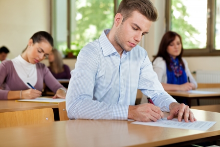
Male student in a classroom with a students behindの写真素材