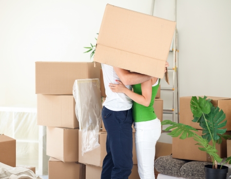 couple kissing under the box during moving houseの写真素材
