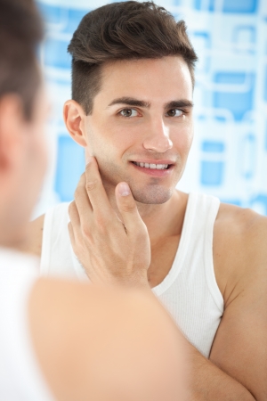 
Portrait of handsome man looking at mirrorの写真素材