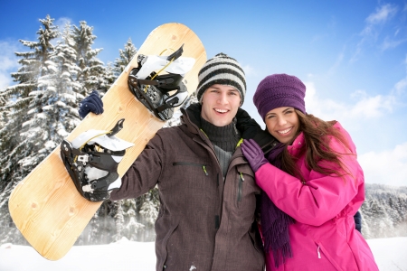
Young adorable couple enjoying in wintertime with snowboardの写真素材