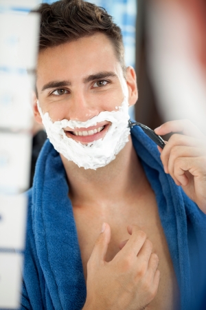 Portrait of smiling handsome shaving man in bathroomの写真素材