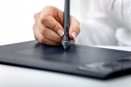 
digital graphics tablet and a hand hold a stylus used for graphic design and digital art manipulationの写真素材