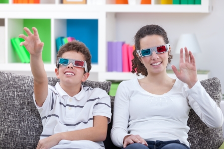 children watching TV with 3D glasses at home の写真素材