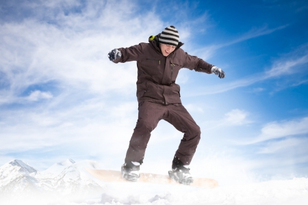 
Snowboarder jumping against blue sky with powder snowの写真素材