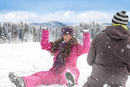 
Winter couple having fun playing in snow outdoors, snowball fightの写真素材