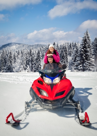 
Couple driving snowmobile in winter mountainの写真素材