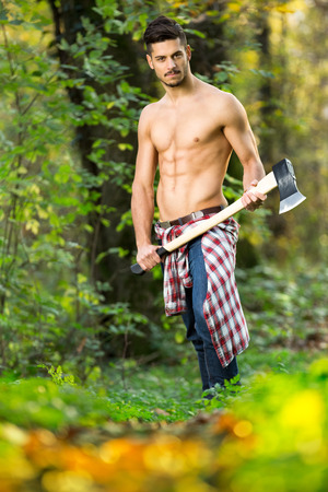Young muscular lumberjack working in forest の写真素材