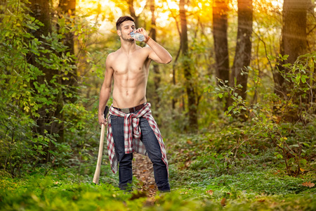fitness lumberjack drinking water in forest  の写真素材