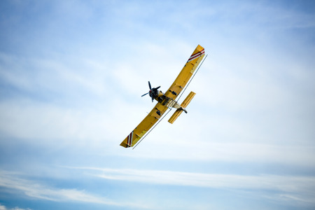 beautiful yellow aircraft is flying in the skyの写真素材
