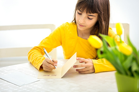 
cute little girl making a card for her momの写真素材