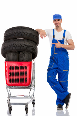 young  mechanic shopping  new tires, isolated over white の写真素材