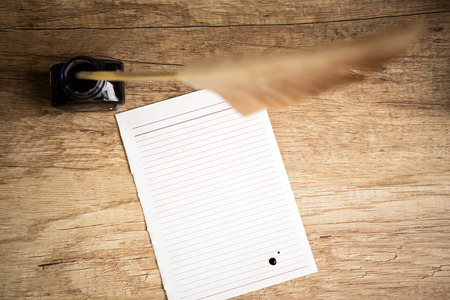 
Retro workplace  with goose quill and inkpot on wooden tableの写真素材