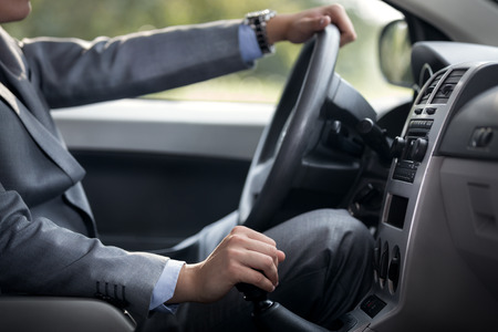 man driving car with hand on gearboxの写真素材