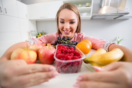 young woman in kitchen with healthy foodの写真素材