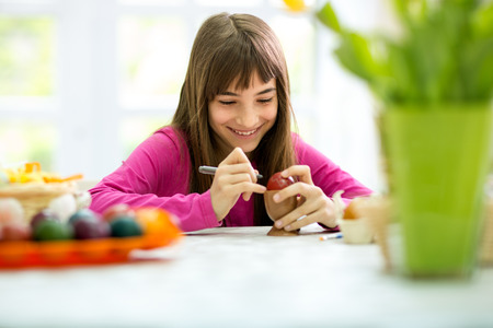 smiling girl coloring Easter eggsの写真素材