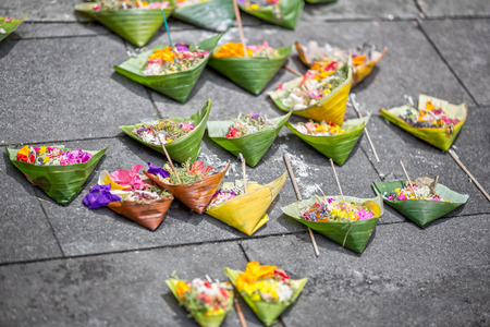 Offerings to gods in Bali with flowers, food and aroma sticksの写真素材