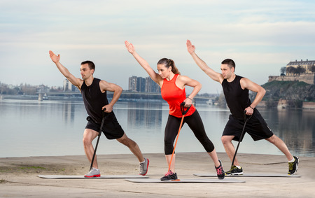 Group of young people doing exercise with resistance rubberの写真素材