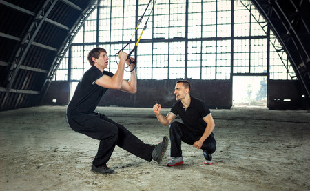man exercising with a resistance band with trainerの写真素材