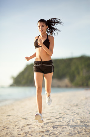 Young woman running alone on the beach.の写真素材