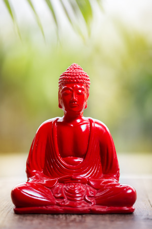 Red Buddha over bright nature backgroundの写真素材