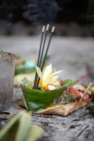 Offerings to gods in Bali with flowers, food and aroma sticksの写真素材
