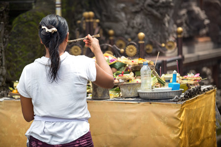 woman praying god in Ubud, Bali, Indonesia, every morning women bring flowers and incense to their godsのeditorial素材