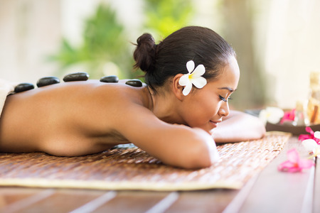 Balinese woman enjoying in hot stone massage in spa salonの写真素材