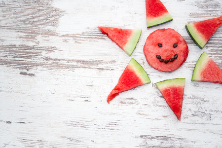 watermelon slices arranged in a corner decoration on a wooden plank background with copyspace for your textの写真素材