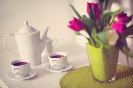 cups of tea with a teapot on decorated tableの写真素材