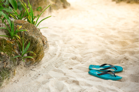slippers Flip Flops on the sandy beachの写真素材