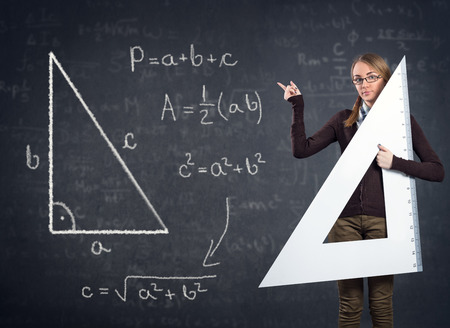 female student with a big ruler pointing at  Pythagorean theorem on blackboard