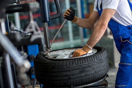 engineer  balancing  car wheel on balancer in workshop