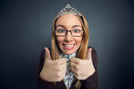 Teen nerd prom queen showing thumbs upの写真素材